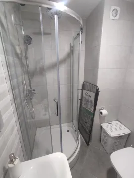Bright bathroom with a semi-circular shower cabin. - image 11