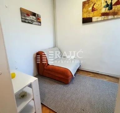 Living room with a sofa and paintings on the wall. - image 7