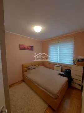 Nameštena spavaća soba sa bračnim krevetom, komodom i prozorom. - image 9