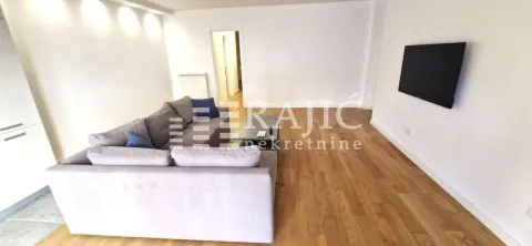Spacious living room with a sectional sofa and a wall-mounted TV. - image 6
