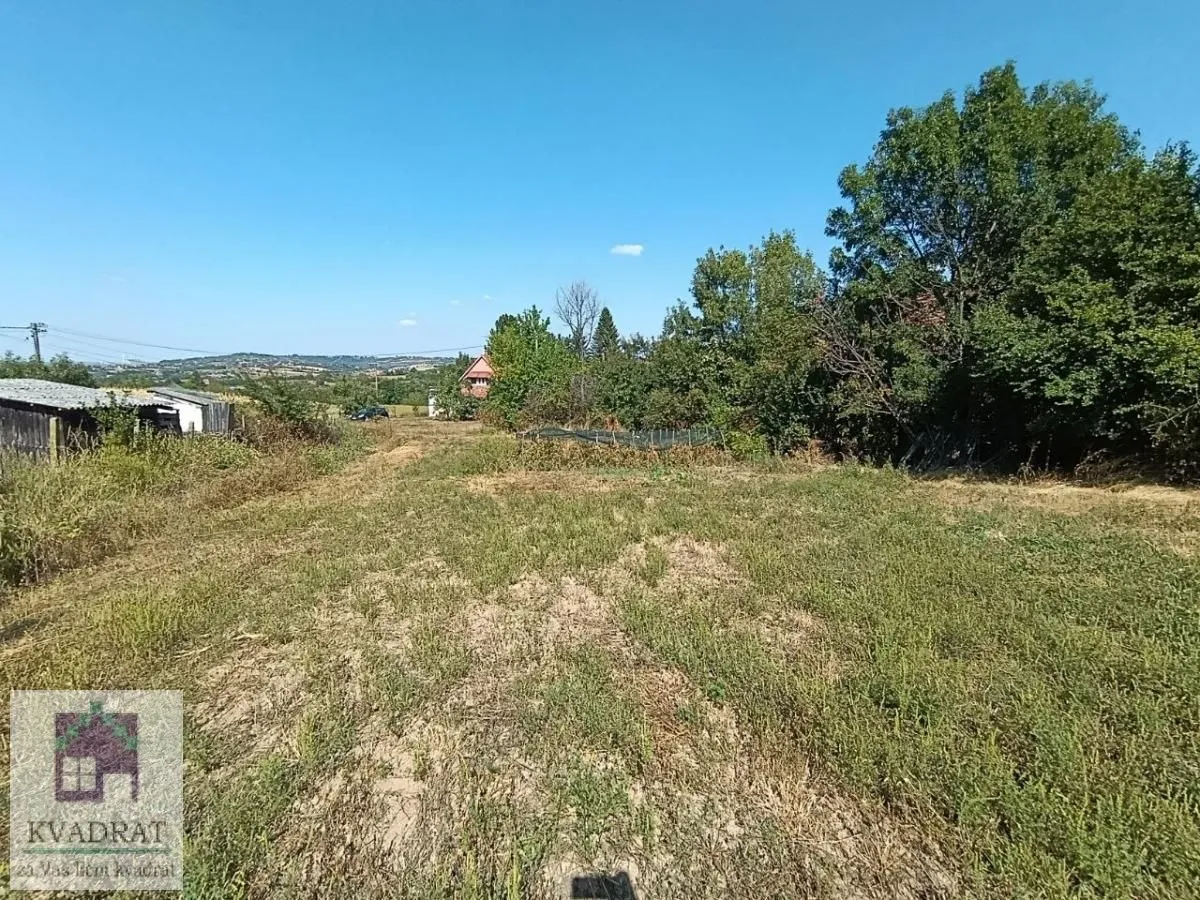 Pogled na plac sa zelenilom i okolnim rastinjem.