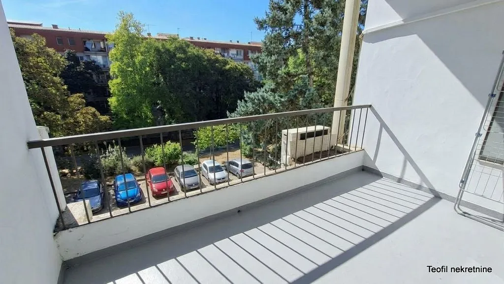 View from the balcony overlooking the parking lot and greenery.