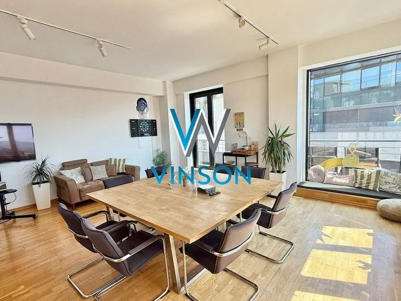 Spacious living room with a dining table and large windows.