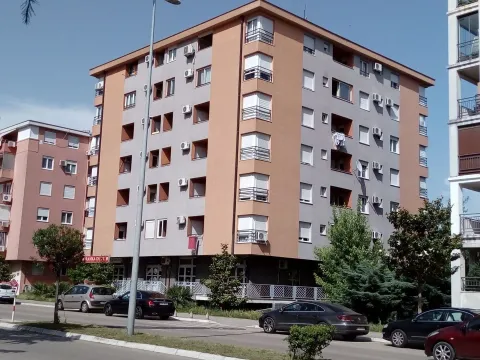 Exterior of a multi-story residential building with parking in front. - image 10