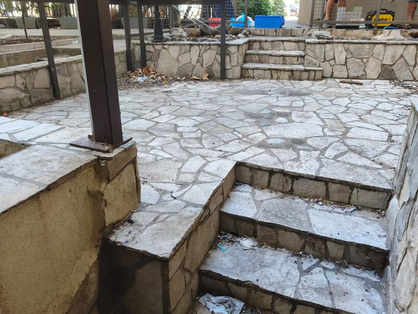 Stone-paved yard with stairs and retaining walls.