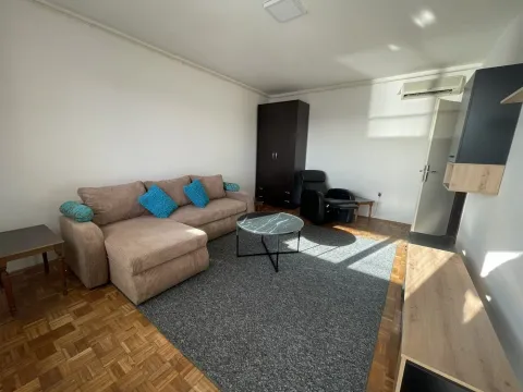 Living room with a corner sofa, coffee table, and parquet flooring. - image 2