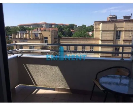 Smaller furnished balcony overlooking surrounding buildings. - image 14