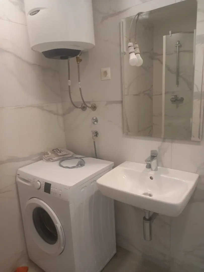 Kupatilo opremljeno umivaonikom, veš mašinom i bojlerom.