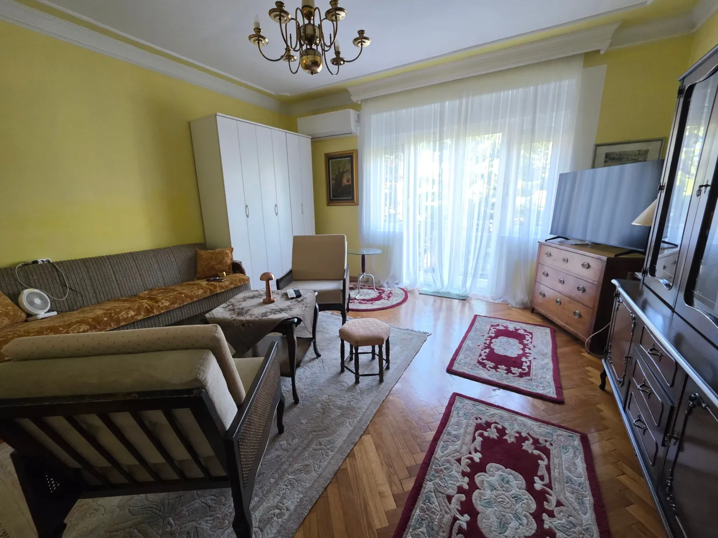 Furnished living room with seating set, television, and access to the terrace.
