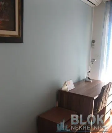 A desk with a chair against the wall in a room.