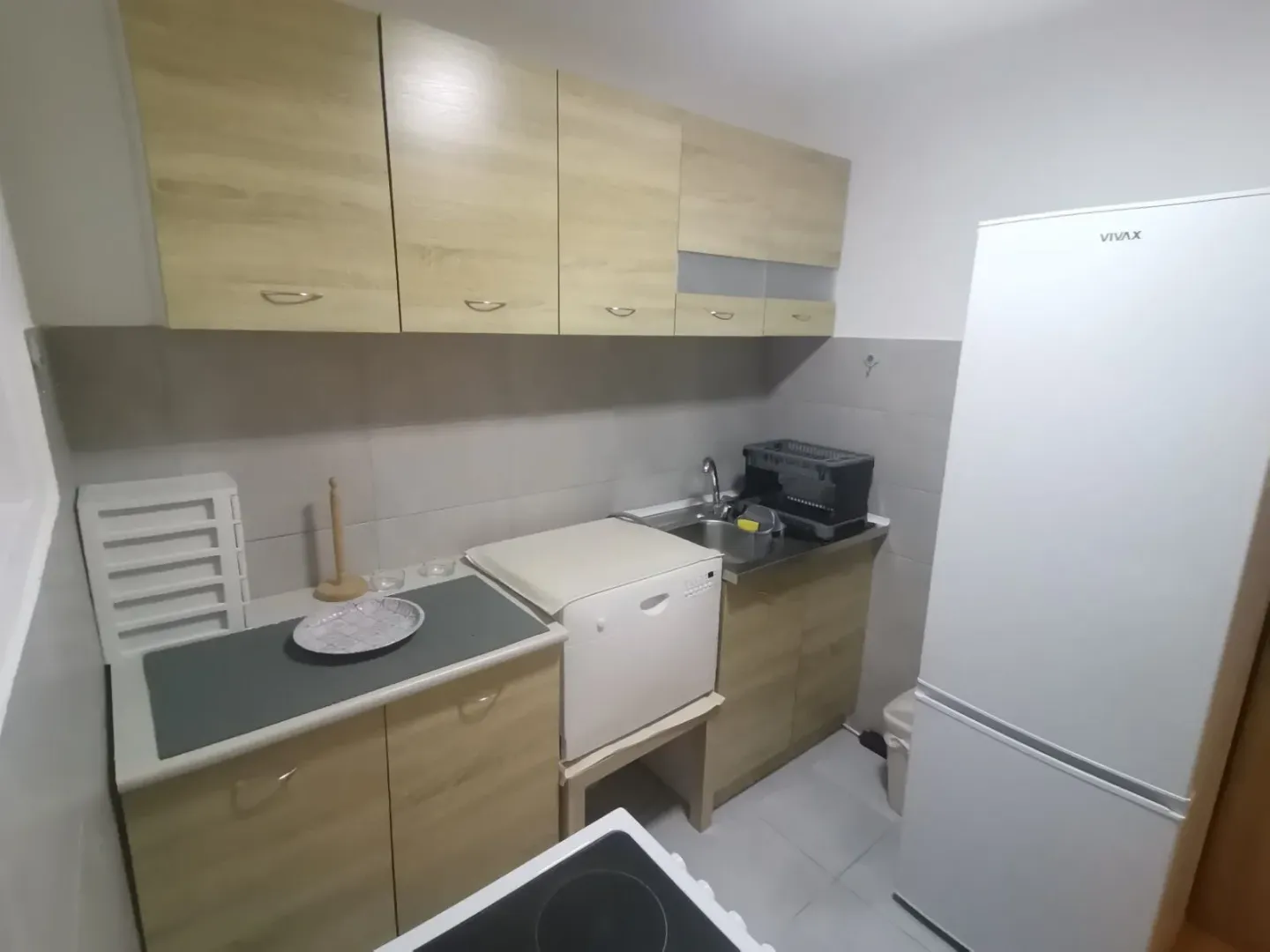 Small kitchen with light cabinets and a refrigerator.