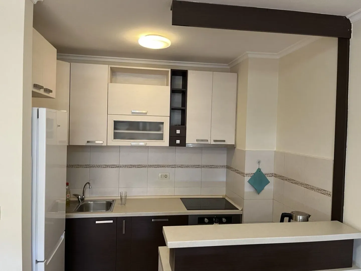 A kitchen with light upper and dark lower cabinets.