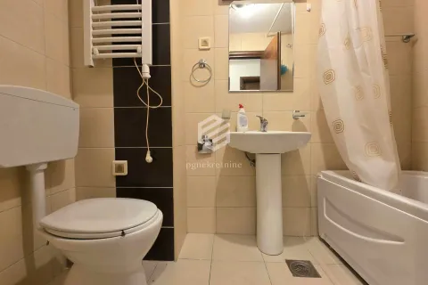 Bathroom equipped with a toilet, washbasin, and bathtub with a curtain. - image 4