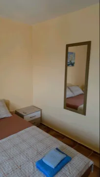 Furnished bedroom with a bed and a wall mirror. - image 12