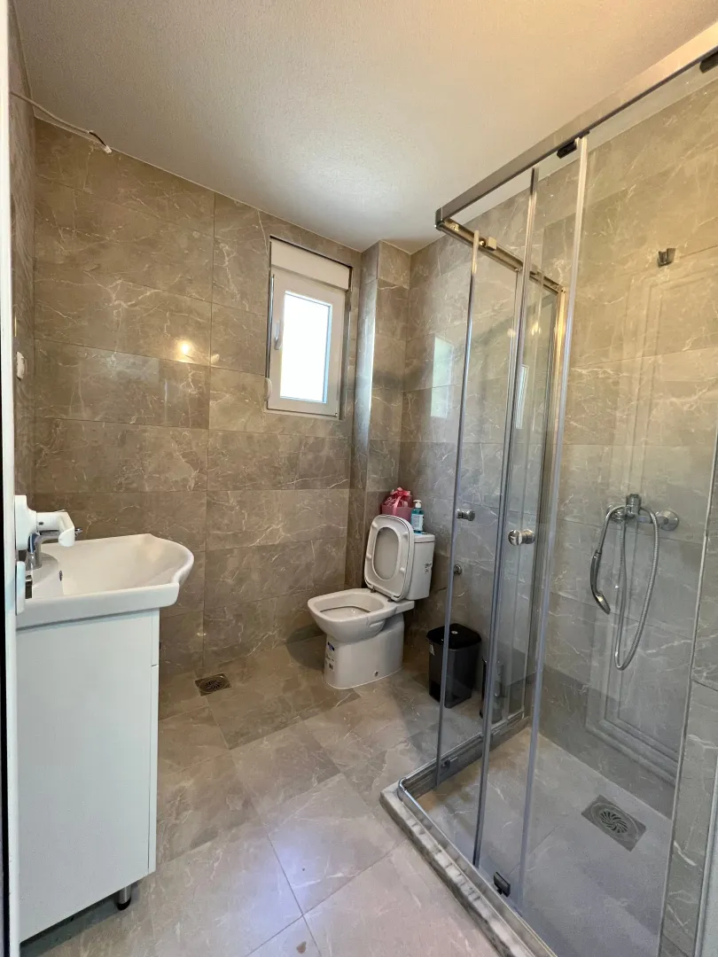 Bathroom equipped with a shower cabin, washbasin, and toilet.