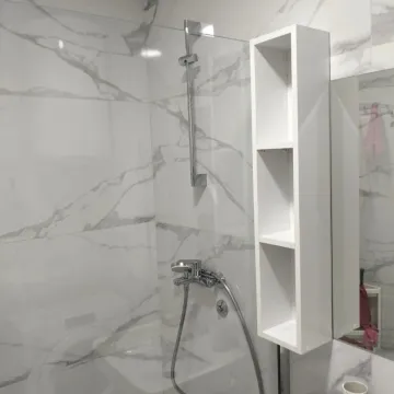 Modern bathroom with a shower cabin and marble tiles. - image 5