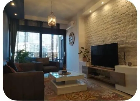 Living room with a sofa set, television, and coffee table.