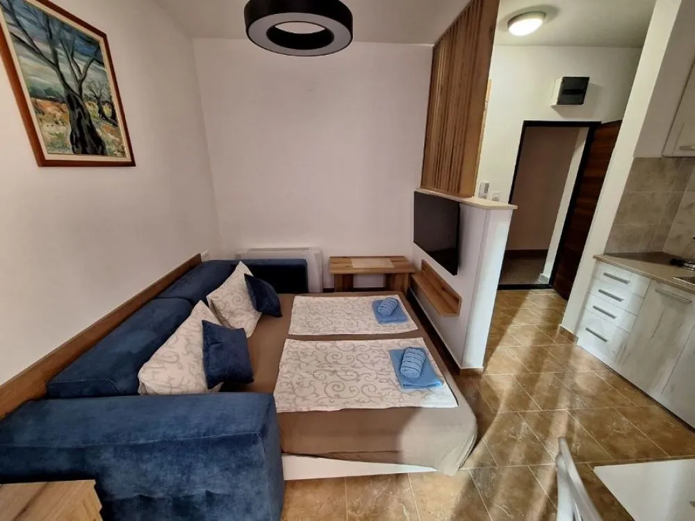 Living room with a corner sofa and a kitchen area.