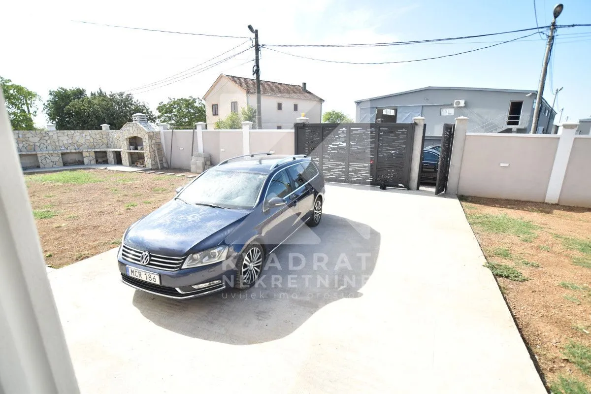 Yard with parking space and a gate in front of the house.
