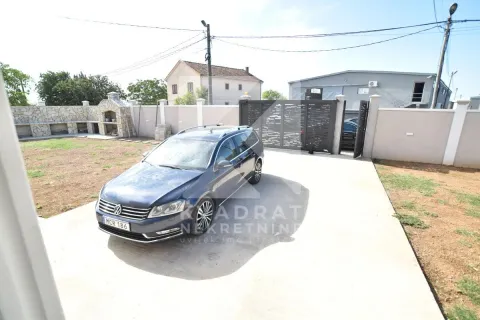 Yard with parking space and a gate in front of the house. - image 5