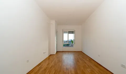 Prazna soba sa bijelim zidovima, parketom i prozorom. - image 4