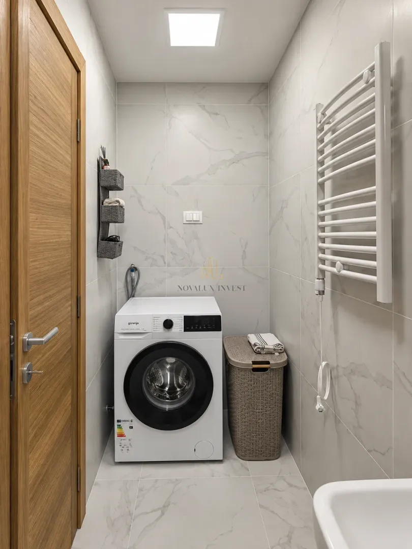 Bathroom equipped with a washing machine and a white towel radiator.
