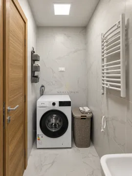 Bathroom equipped with a washing machine and a white towel radiator. - image 9