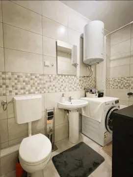 Small bathroom with sanitary fixtures, mirror, and washing machine. - image 8