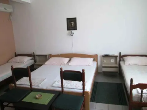 Spavaća soba sa nekoliko kreveta i noćnim stočićima. - image 7