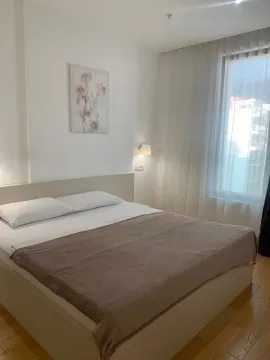 Svjetla i uredna spavaća soba sa bračnim krevetom i velikim prozorom. - image 9