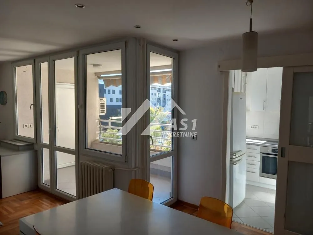 Living room with a dining table and a view of the terrace.
