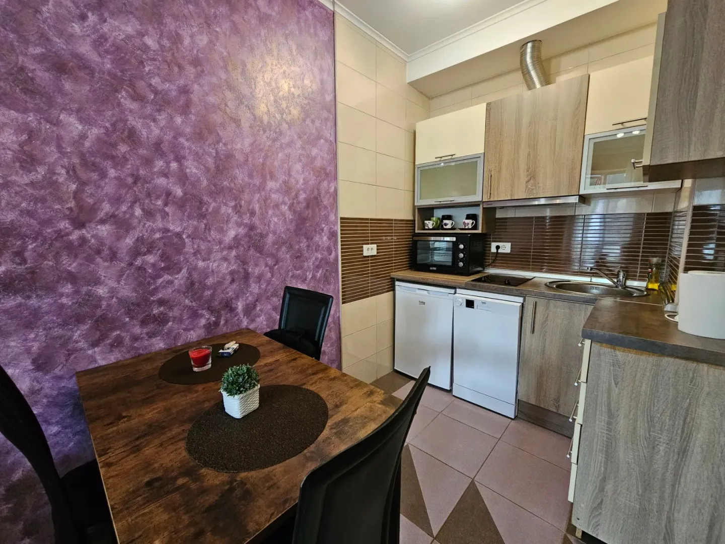 Kitchen with a dining table and a purple wall.