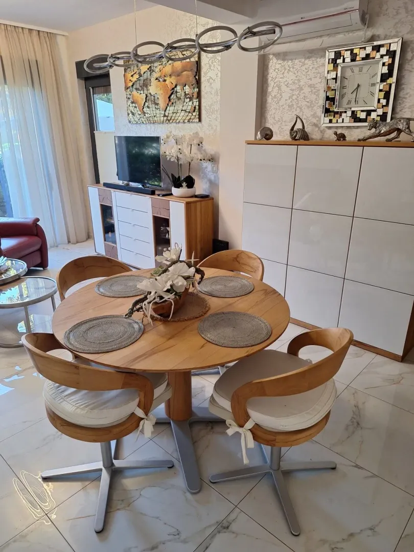 Dnevna soba sa trpezarijskim stolom i modernim namještajem.