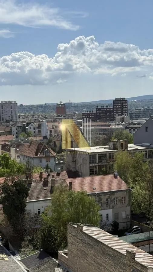 Pogled na grad sa visoke pozicije sa krovovima zgrada u prvom planu.