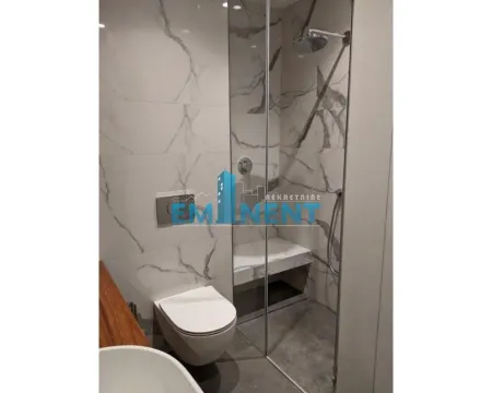 Modern bathroom with a walk-in shower tiled in marble and a wall-hung toilet. - image 11