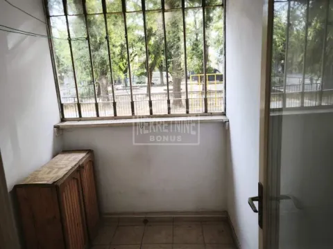 Zastakljeni balkon sa zaštitnim rešetkama na prozorima i pogledom na zelenilo. - image 3