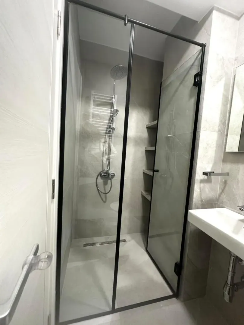 Modern bathroom with a walk-in shower and a washbasin.