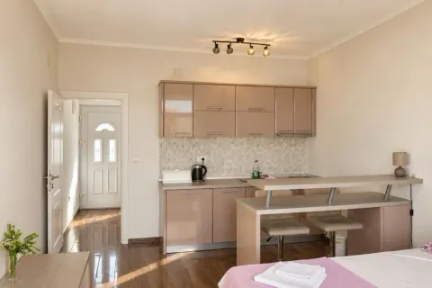 Kuhinja u sklopu manjeg stana sa trpezarijskim dijelom i izlazom u hodnik. - image 4