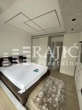 Modern bedroom with a double bed, built-in wardrobes, and a drop ceiling. - image 2