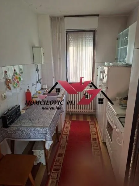 Manja kuhinja sa trpezarijskim stolom i prozorom.