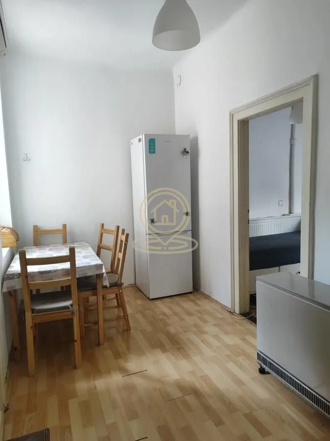 Smaller kitchen with a dining table and a refrigerator.