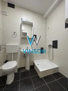 Small bathroom with a shower cabin, washbasin, and toilet. - image 12