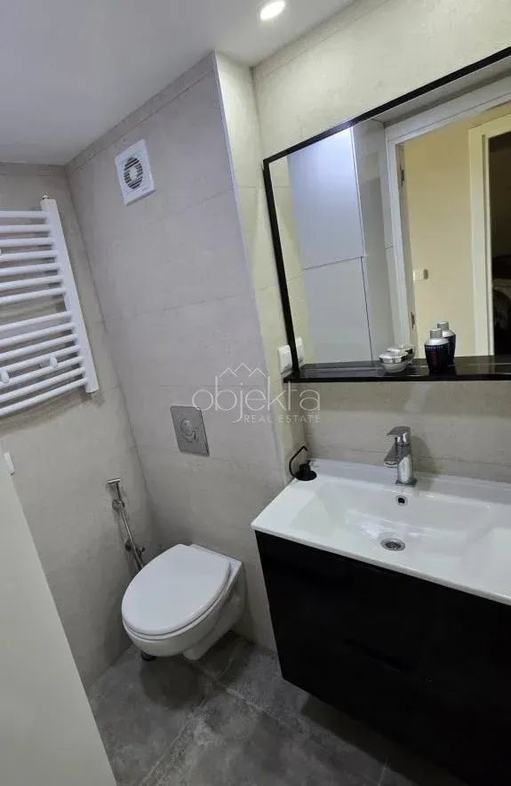 Moderne kupatilo sa umivaonikom, ogledalom i wc šoljom.