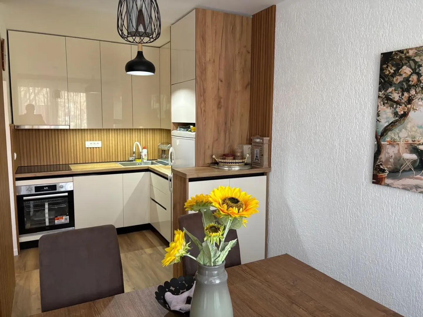 Kitchen with beige and wooden cabinets and a dining table.