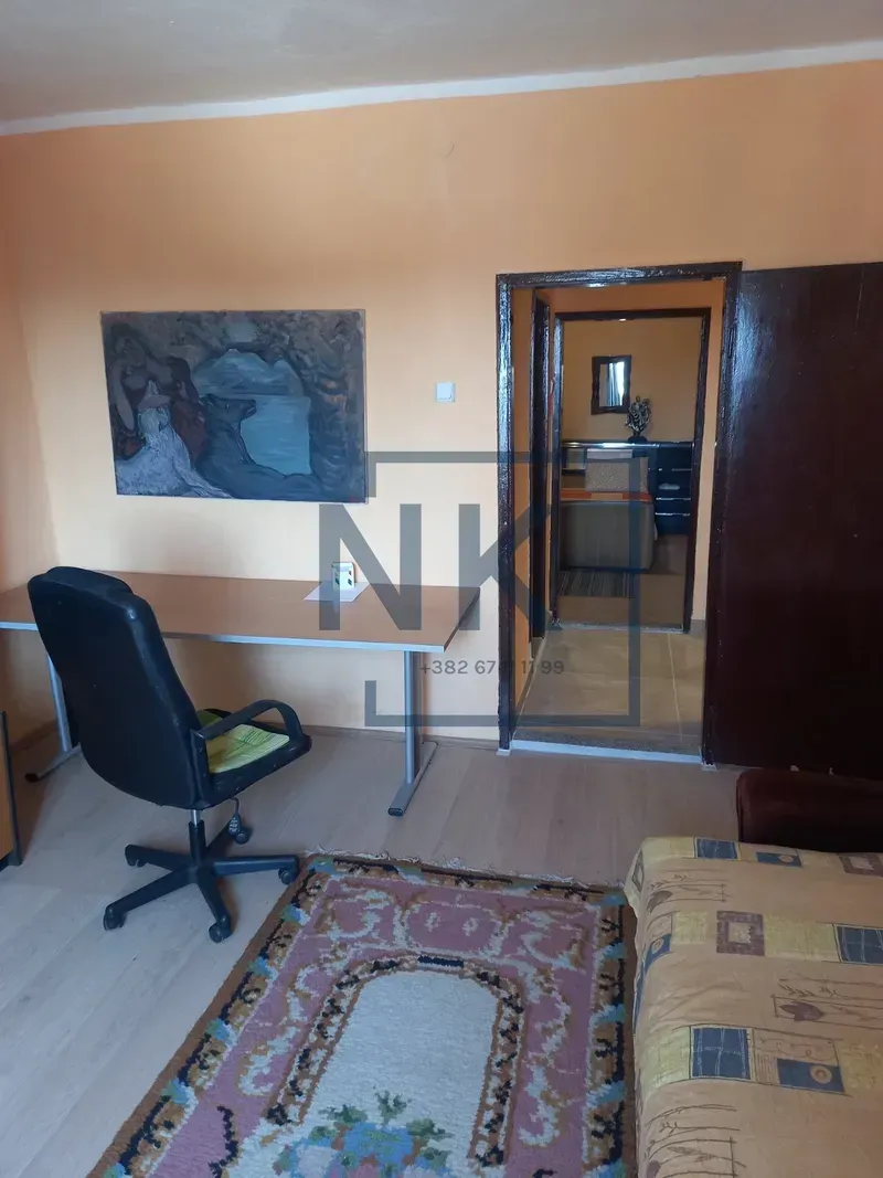 Living room with a desk, office chair, and an artwork on the wall.