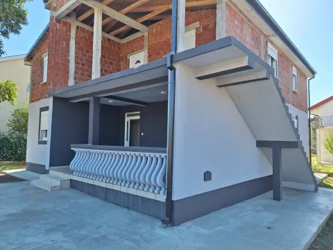 Exterior view of a house under construction with a terrace and outdoor stairs. - image 3
