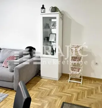 Living room with a sofa and a white display cabinet. - image 4