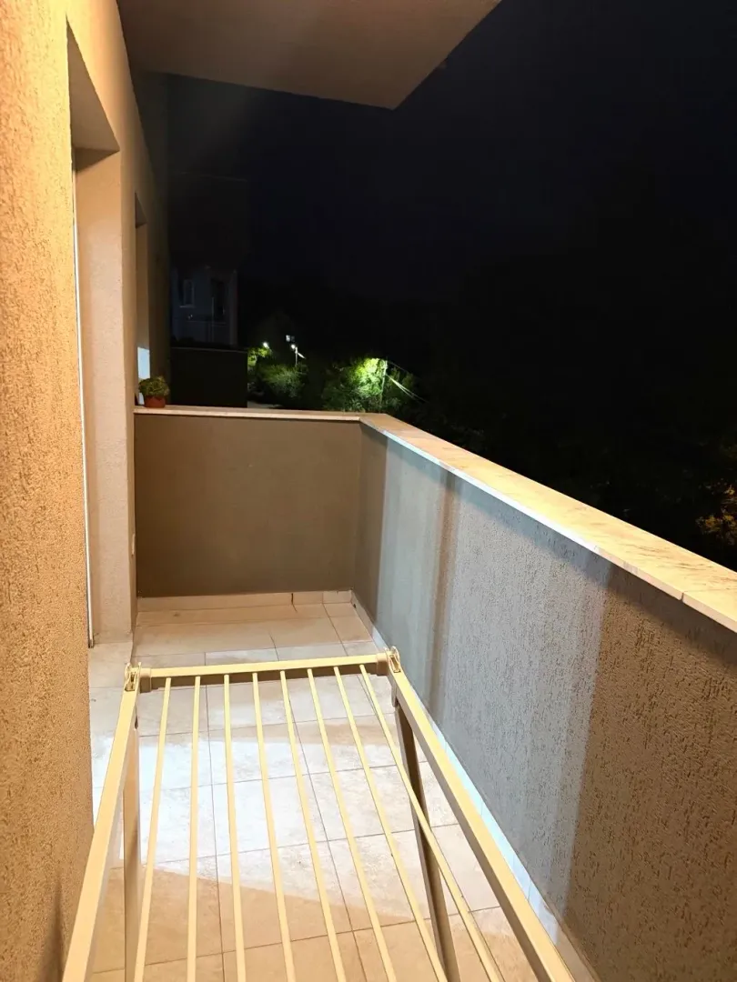 Osvijetljena terasa sa stalkom za sušenje veša noću.