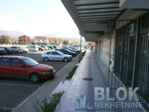 View of the exterior part of the building with a sidewalk and parking lot. - image 9
