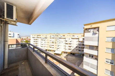 View from the balcony overlooking surrounding apartment buildings and a town square. - image 9